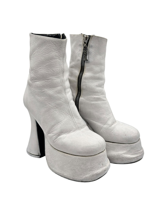 White platform ankle boots with side zip, tall block heel, and rounded platform toe