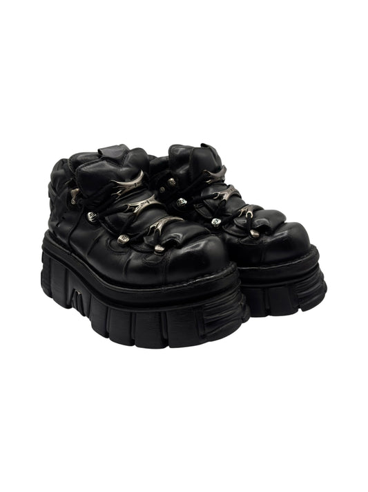 Side view of black platform boots with lace-up laces and thick molded outsole