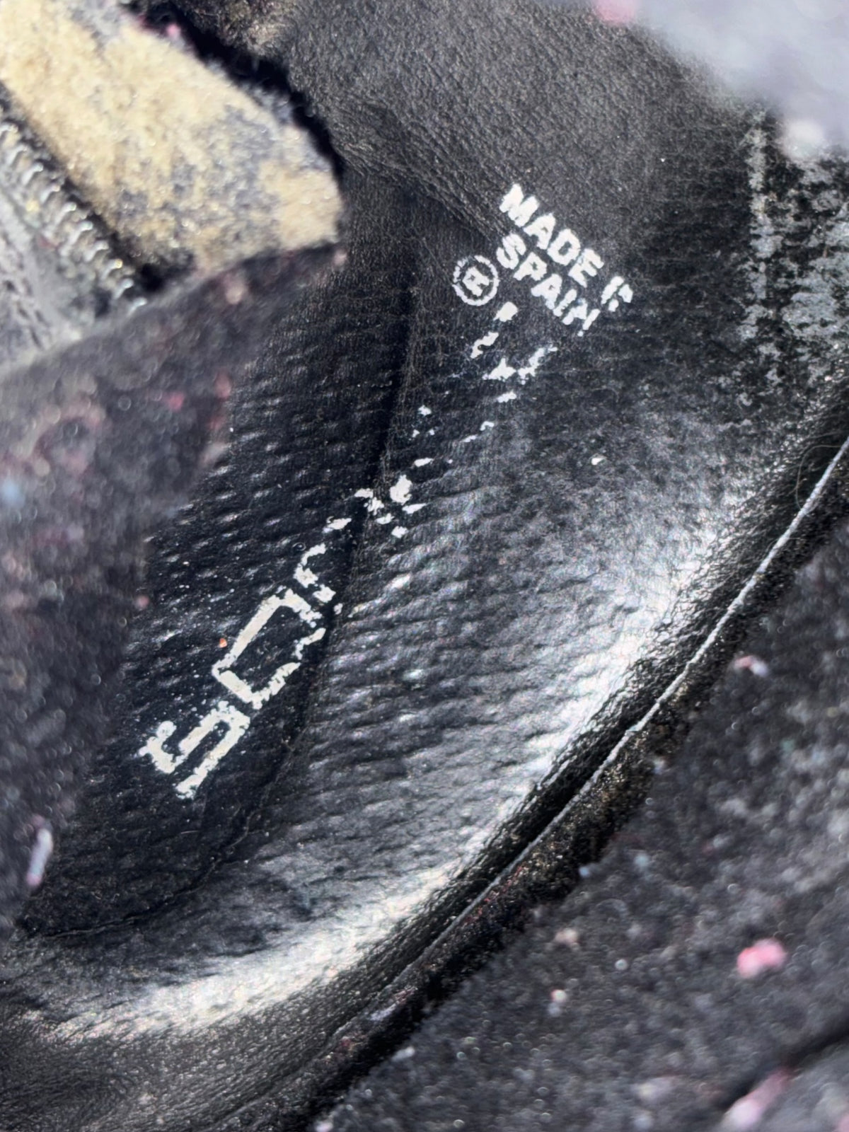 Black leather boot upper with printed brand markings and stitched trim