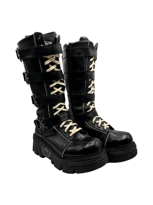 Black knee-high leather platform boots, side view with straps, buckles, and lace-up