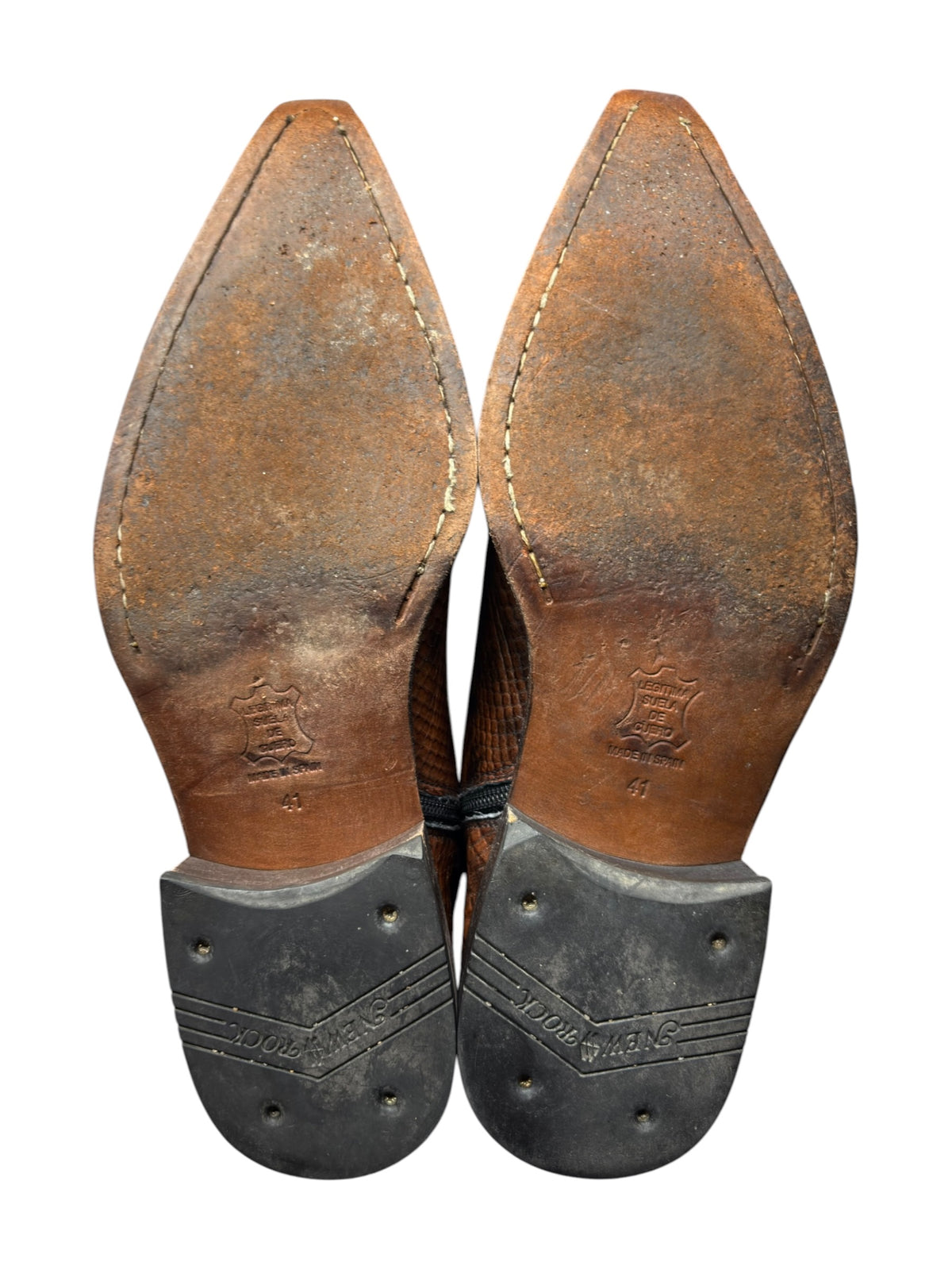 Boot heels and soles with scuffed uppers and black metal heel guards