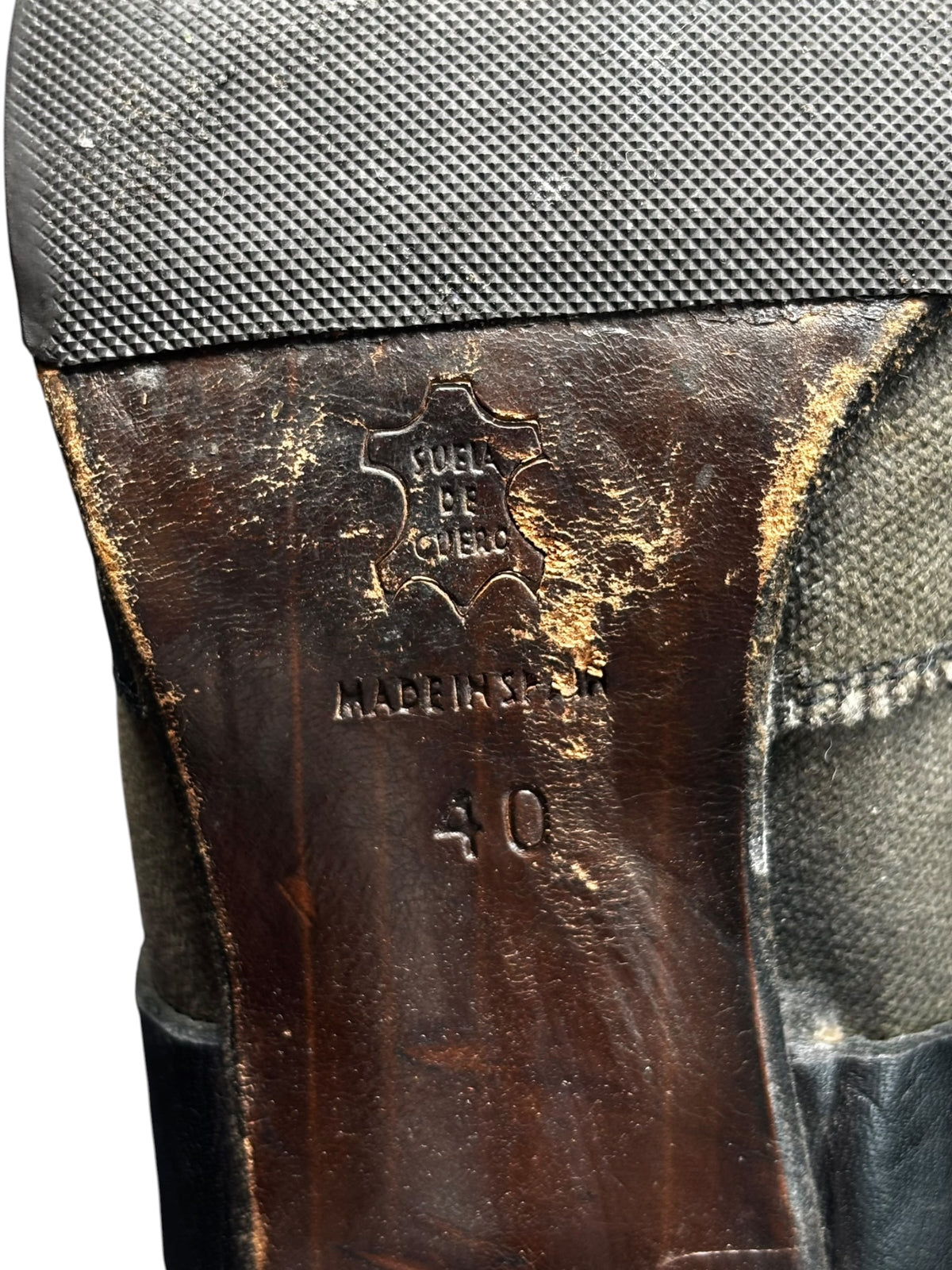 Knee-high boots close-up of heel pull tab with 'Made in' stamp and size markings