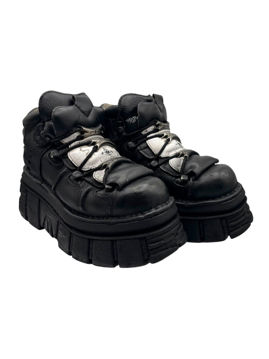 Black platform boots with silver buckle straps, lace-up detail, and lug platform sole