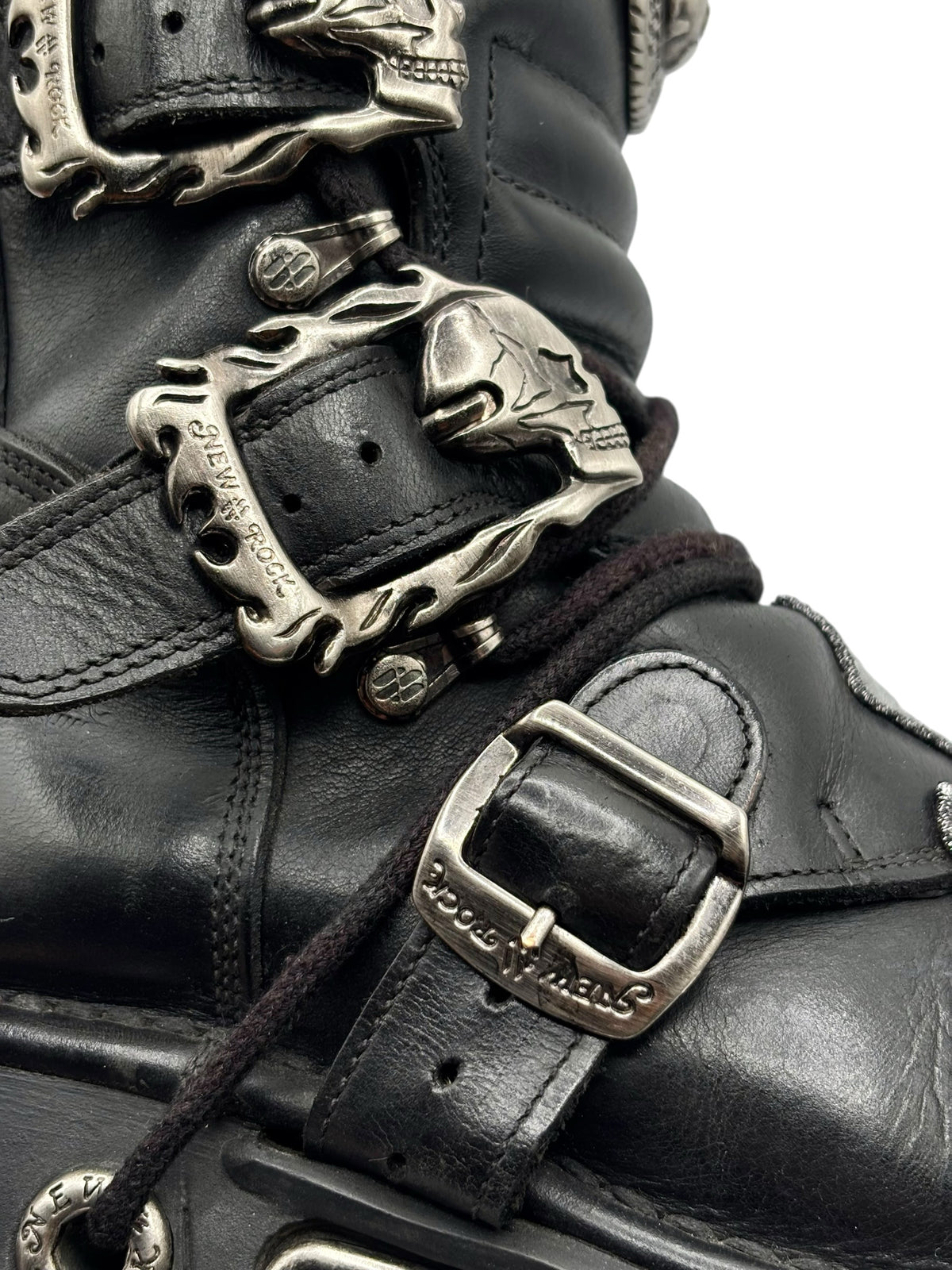 Close-up of black leather boot strap with silver buckle hardware