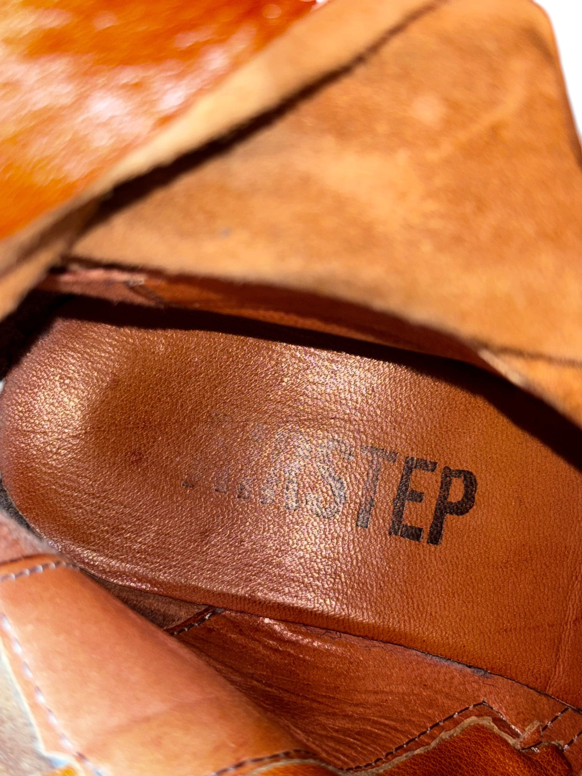 Vintage leather boot insole close-up with dark printed logo detail