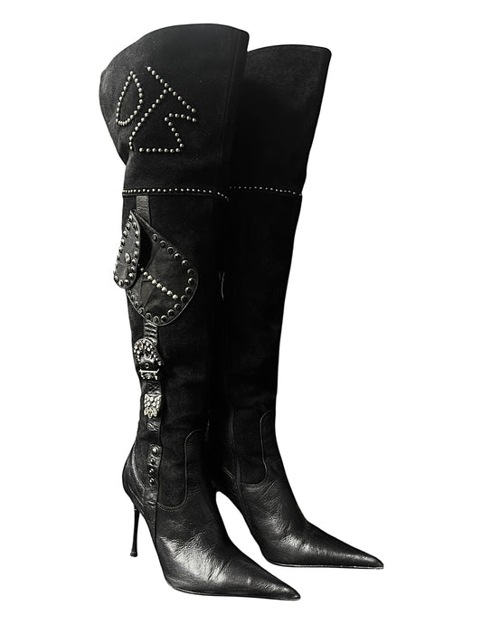 Black tall leather boots with pointy toe, high stiletto heel, and studded shaft motif