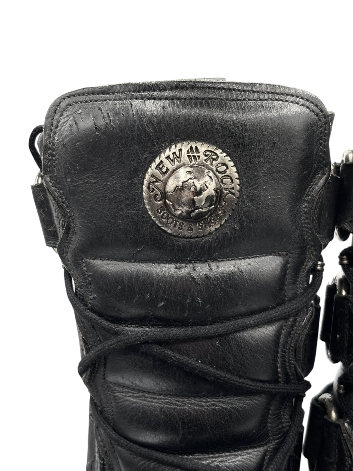 Black knee-high leather boots with round logo patch on the front panel