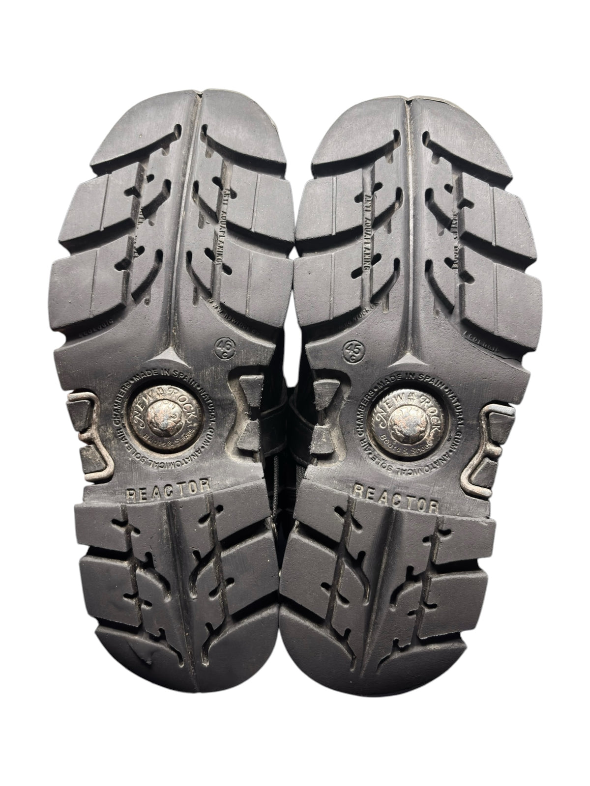Pair of grey New Rock Reactor boots soles with textured tread and circular logo plates.
