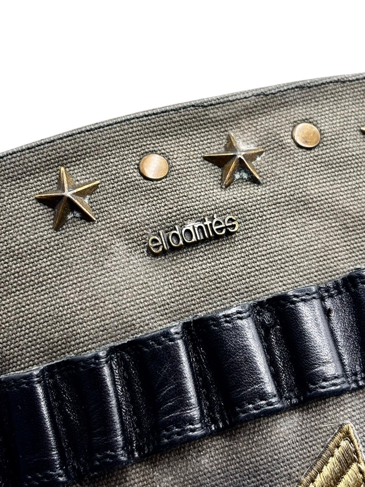 Knee-high boot upper close-up with gold star studs, eldanis logo, and black strap