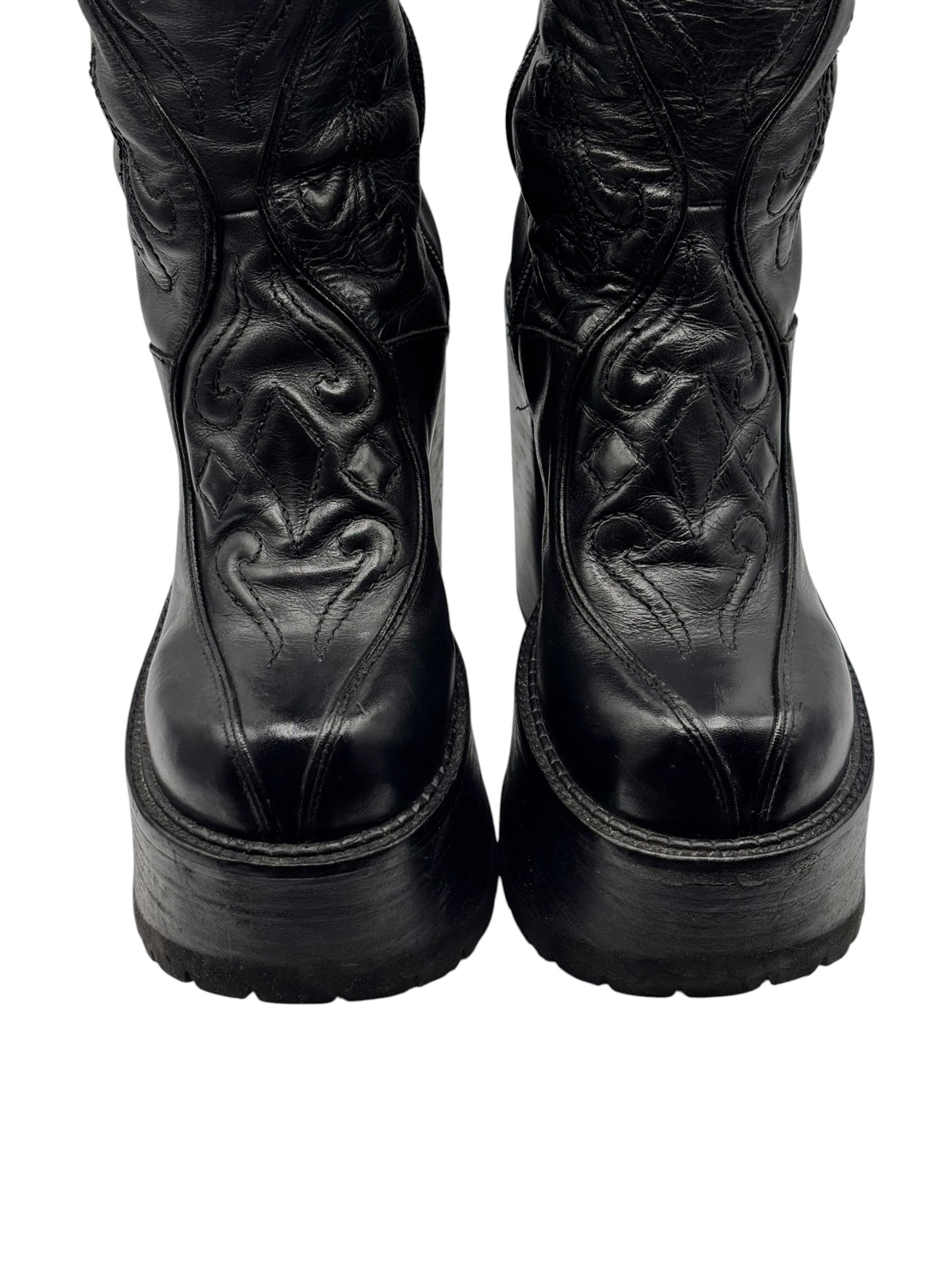 Black knee-high leather platform boots with embossed detail and chunky sole
