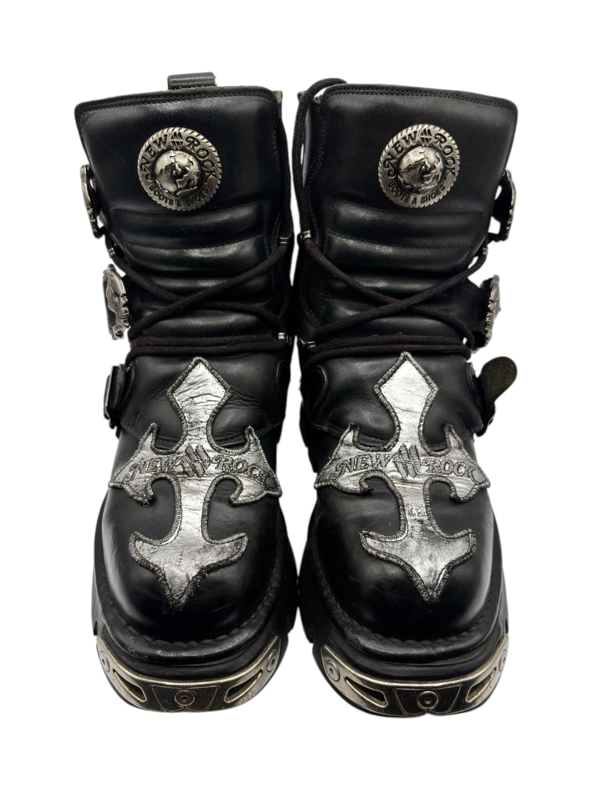 Black lace-up boots with silver circular hardware and silver cross patches