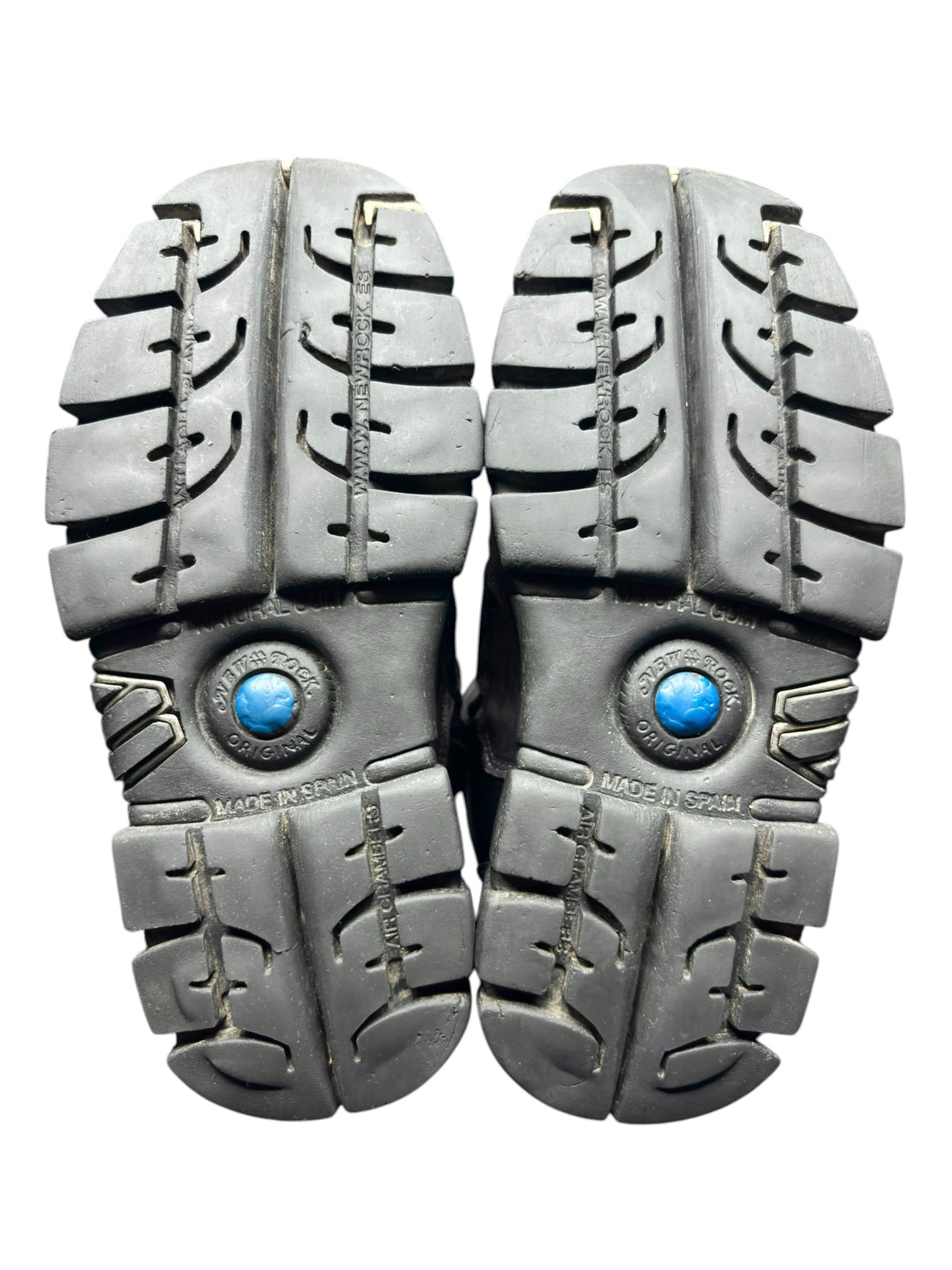 Pair of platform boot soles showing rugged tread, blue emblem, and stacked heel blocks