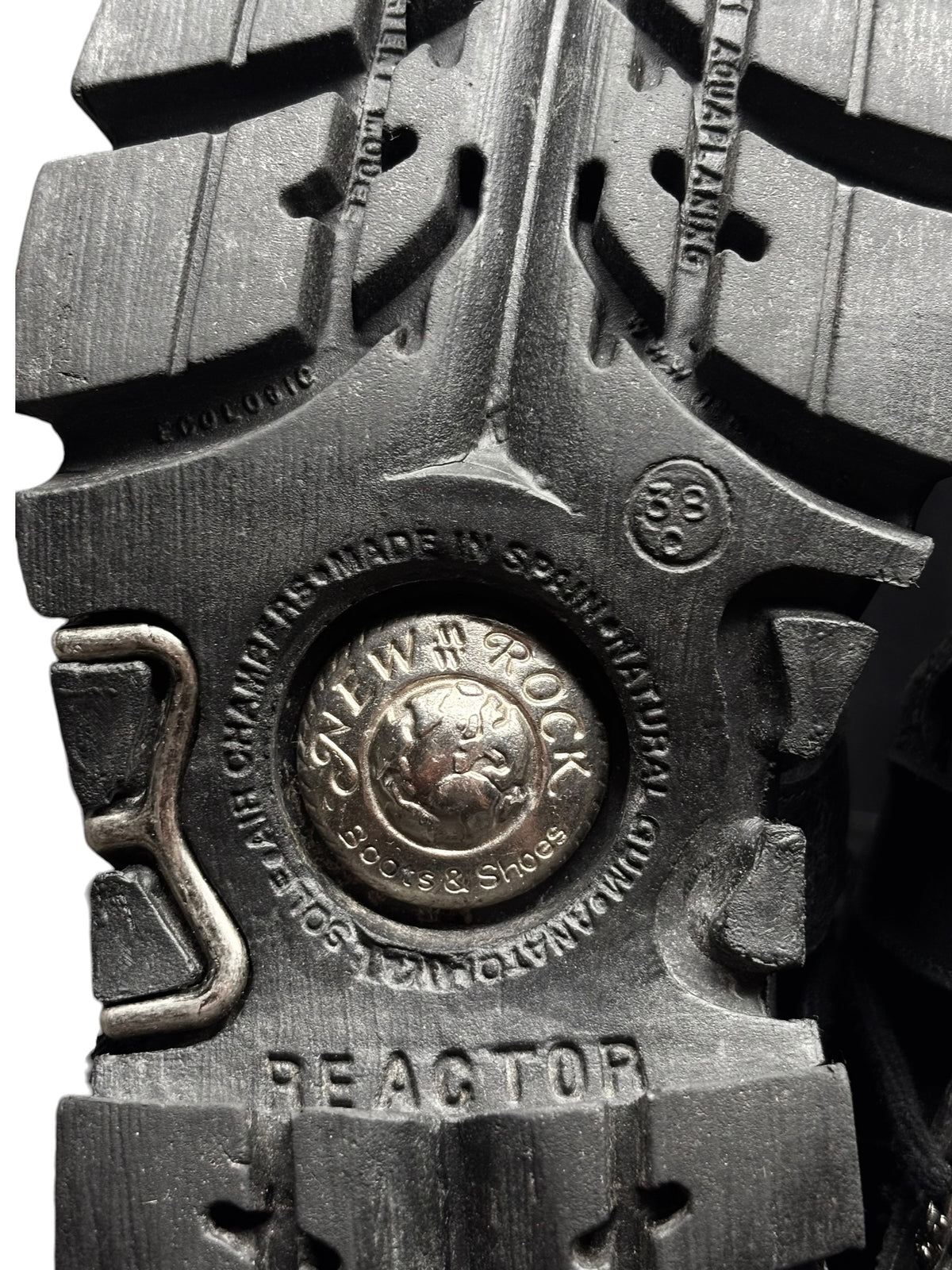 Black platform boot outsole detail with “REACTOR” embossed tread and metal badge