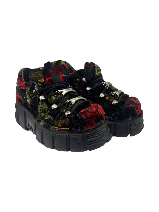 Pair of black platform boots with multicolor flower pattern, lace-up with metal eyelets