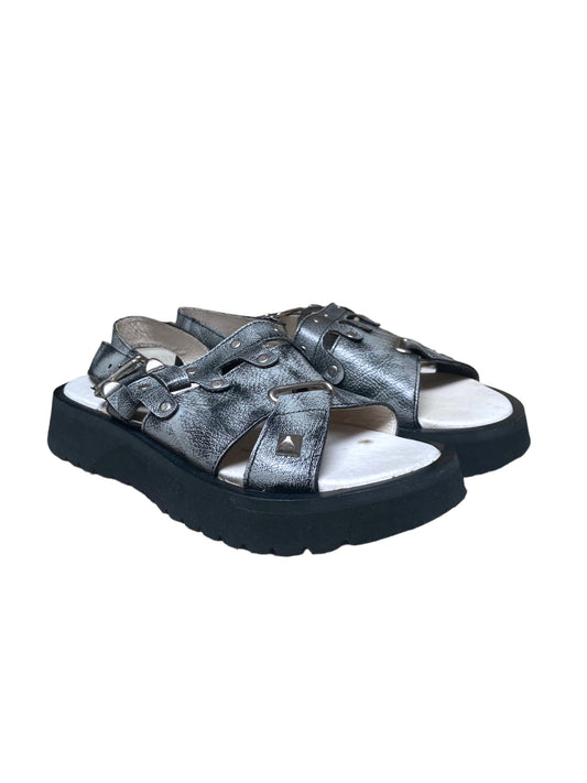 Metallic silver buckle slide sandals with crisscross straps and chunky dark sole
