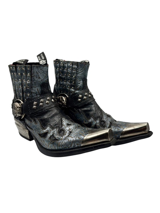 Pair of distressed blue cowboy boots with studded shaft, silver toe caps, and stacked heel