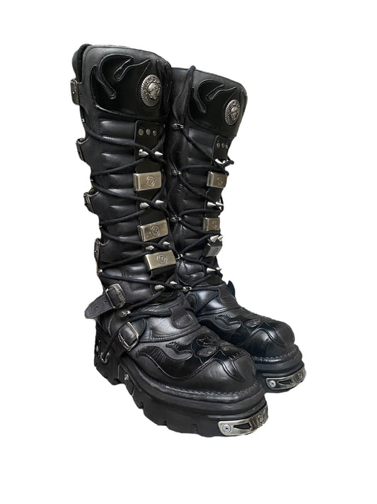 Black knee-high combat boots with buckles and side strap details