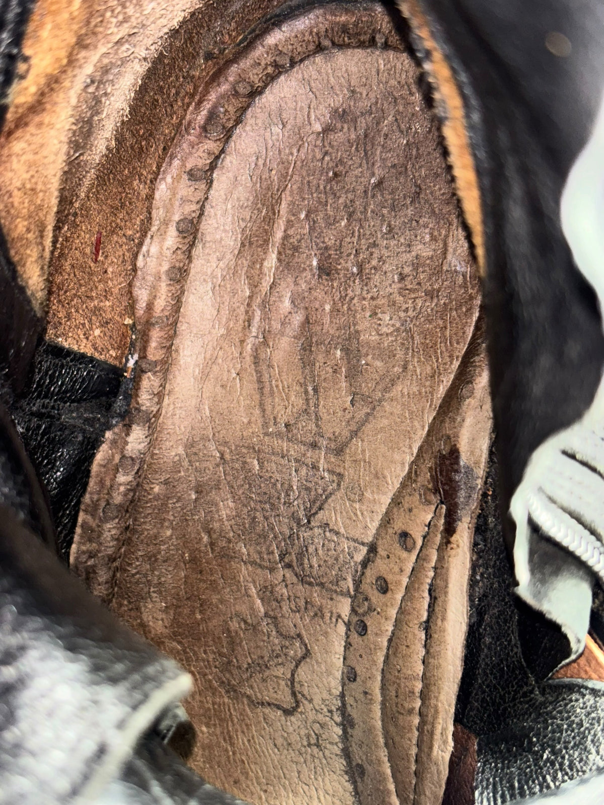 Mid-calf reactor boots with tan insole, stitching, and wear marks at the sole