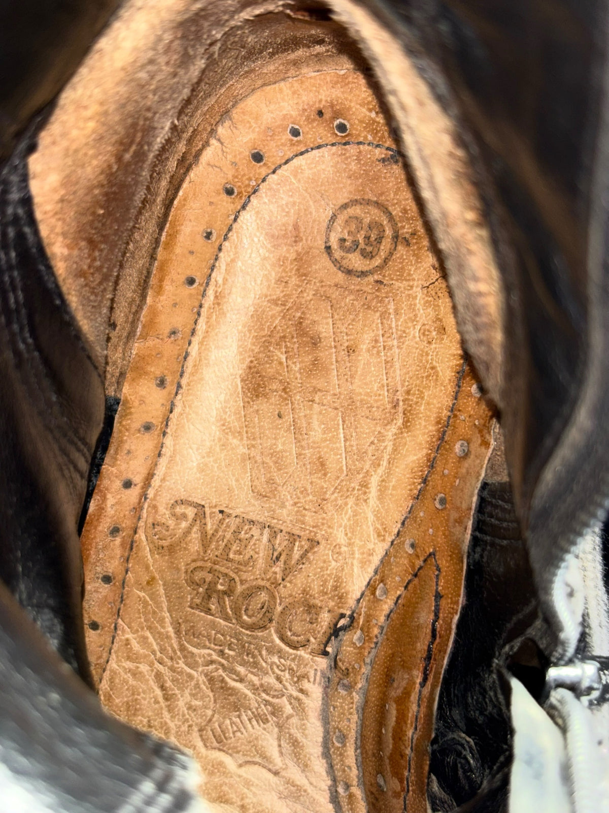Mid-calf boot interior with tan insole and printed logo text