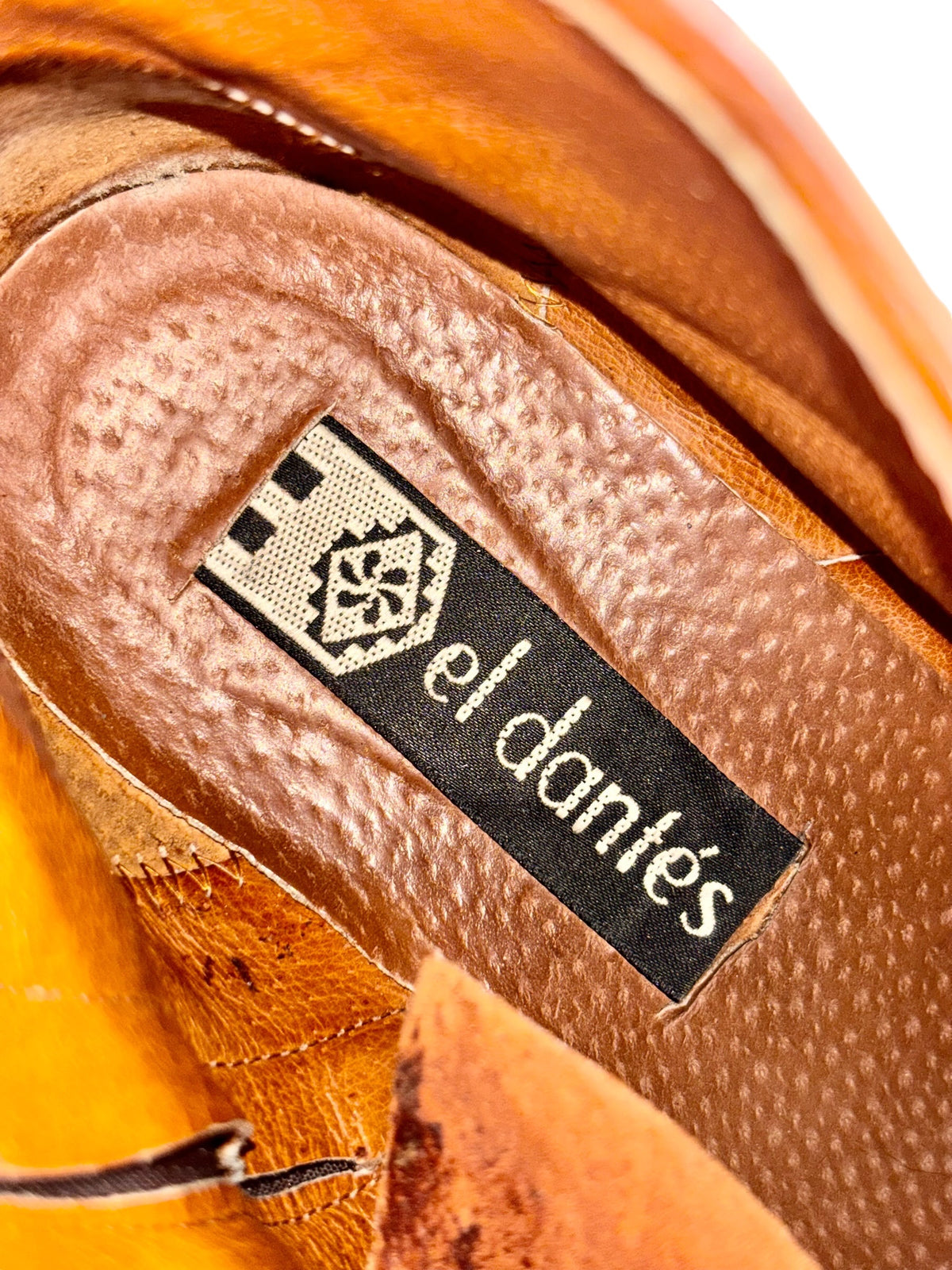 Brown leather boot interior label with “El dantes” brand tag