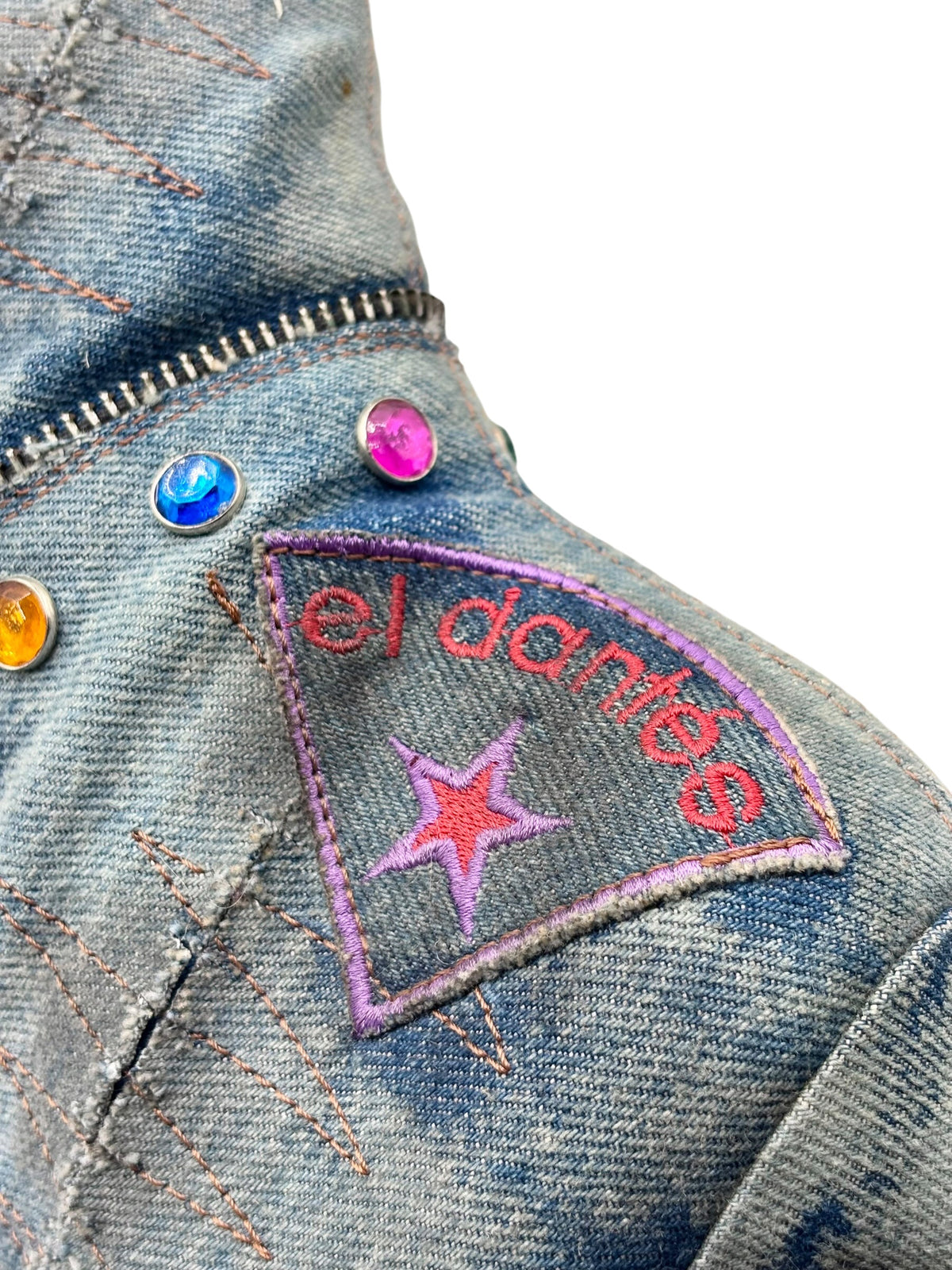 Denim boot upper detail with purple star patch and colorful button accents.