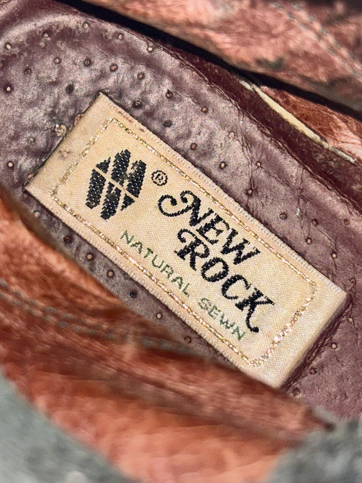 Black leather boot interior label with stamped logo and size text
