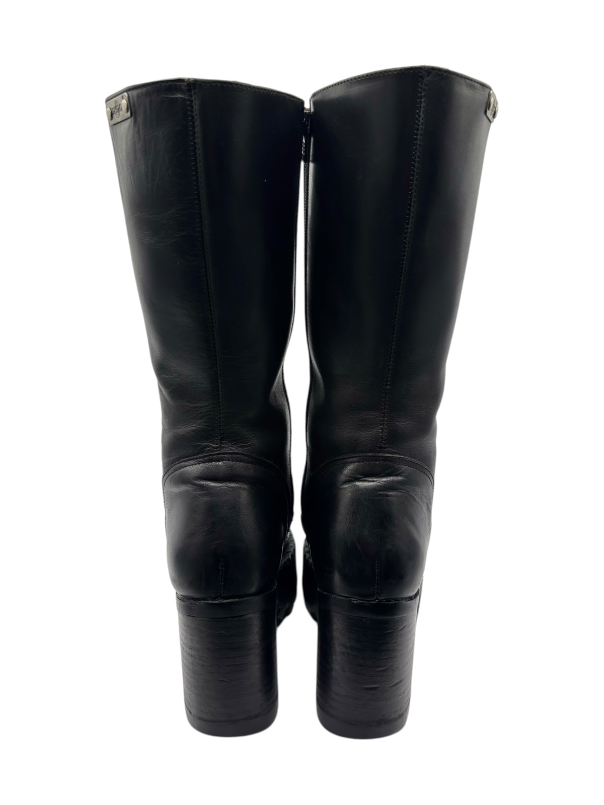 Pair of black knee-high boots shown front view with zipper seams