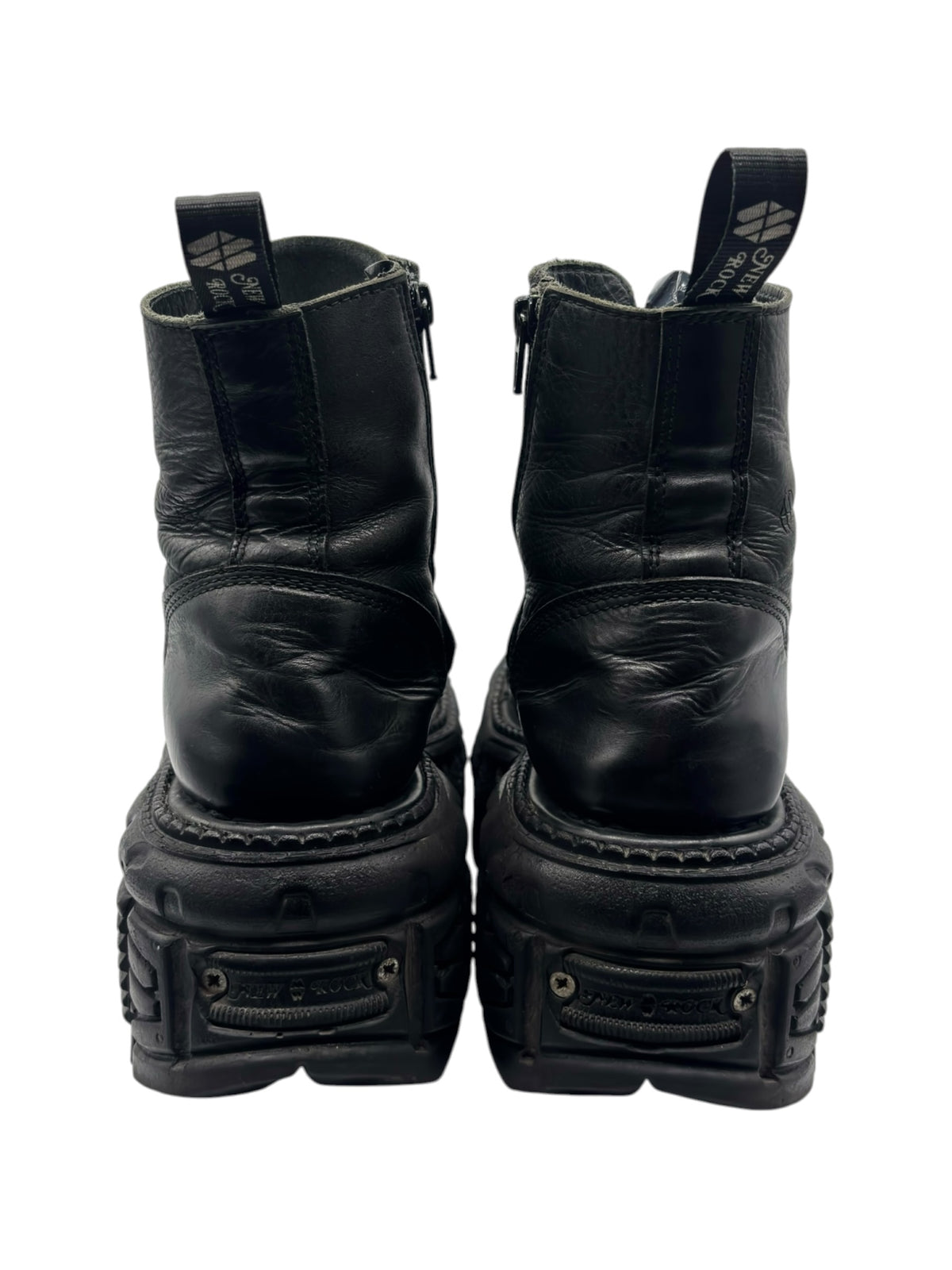 Back view of black platform lace-up boots with chunky tread and ankle heel tabs.