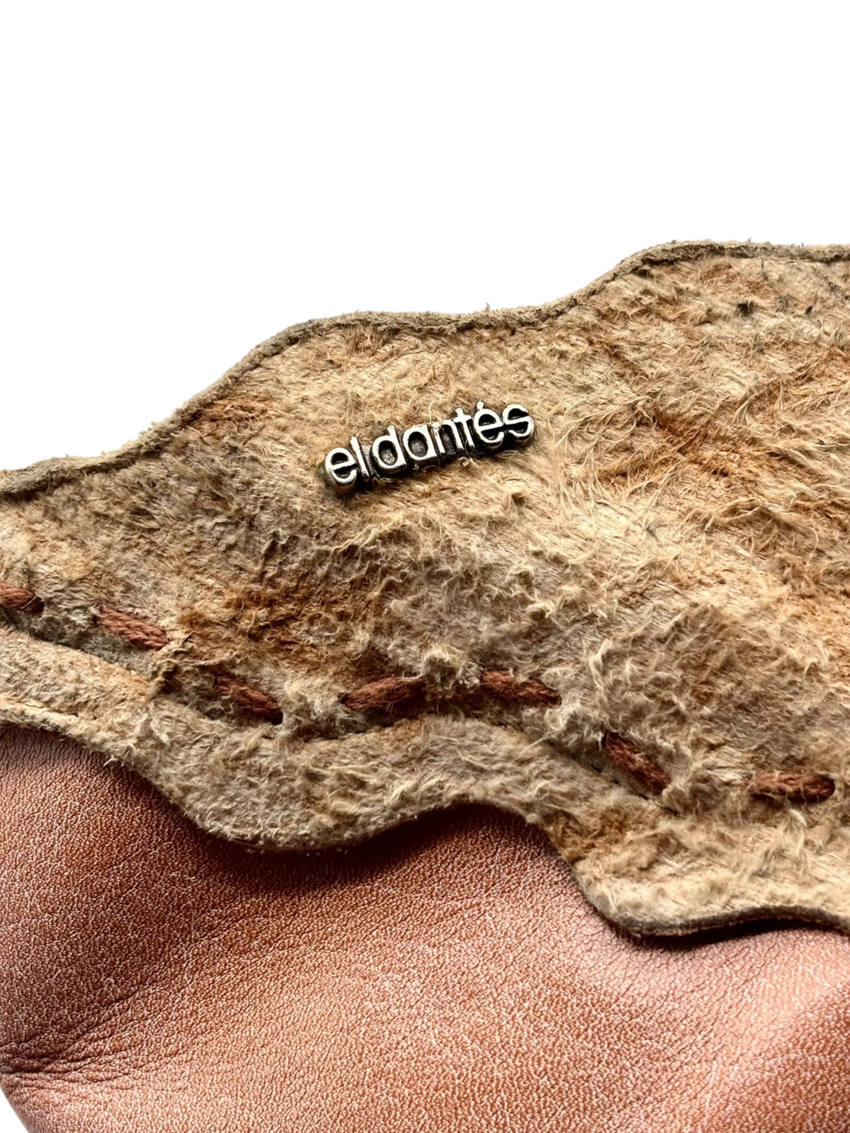 eldantes logo on worn interior lining of beige snake-pattern leather boot