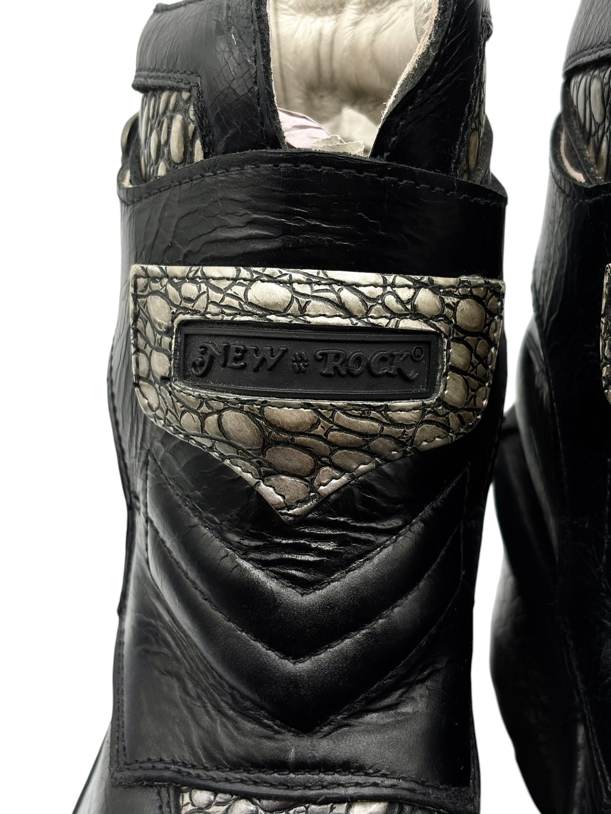 Black and gold textured panel on platform heel with embossed brand logo badge.