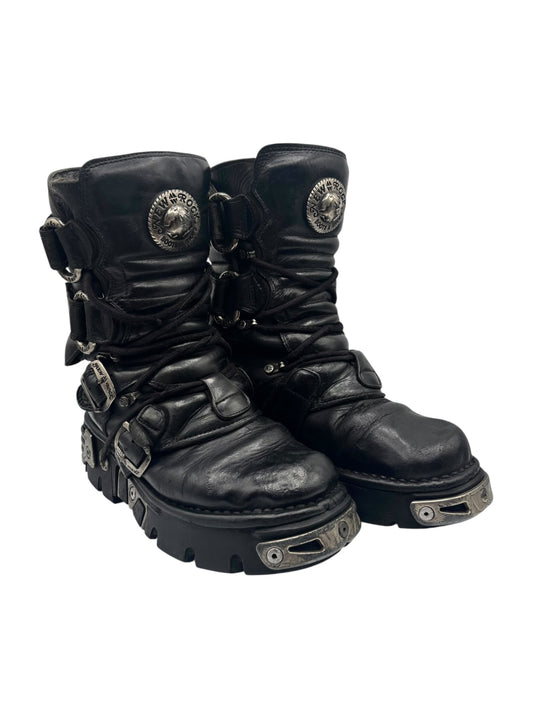 Black leather boots with buckles, lace-up front, and chunky lug outsole