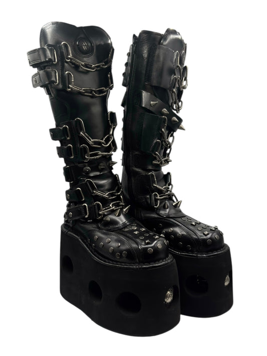 Black studded knee-high platform boots with chunky dark outsole and side straps