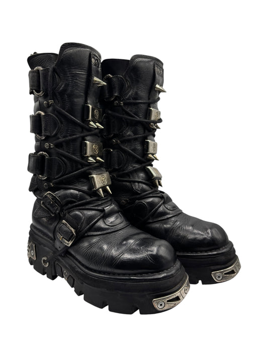 Black knee-high leather boots with side buckles, straps, and rugged treaded sole