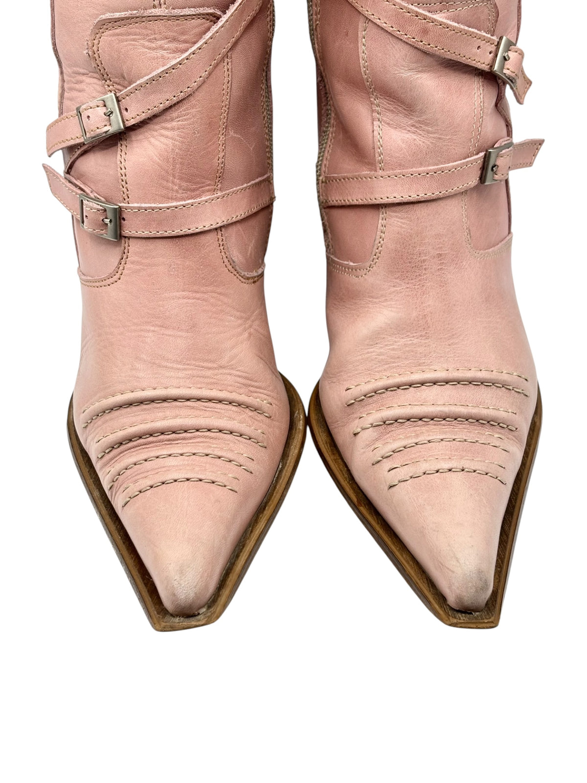 Pink leather pointy-toe boots with two buckle straps and stitched toe panels