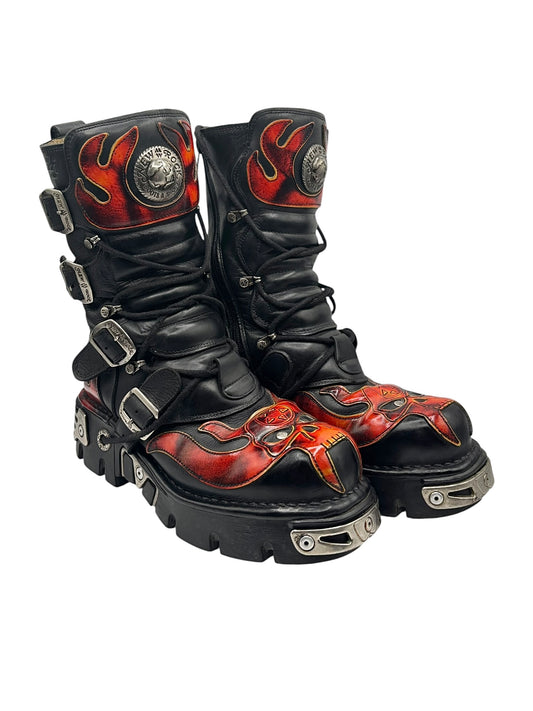 Black lace-up combat boots with red flame panels, buckles, and chunky silver-studded sole.
