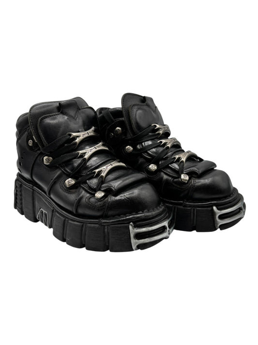 Black platform boots side angle with layered straps and thick lug sole