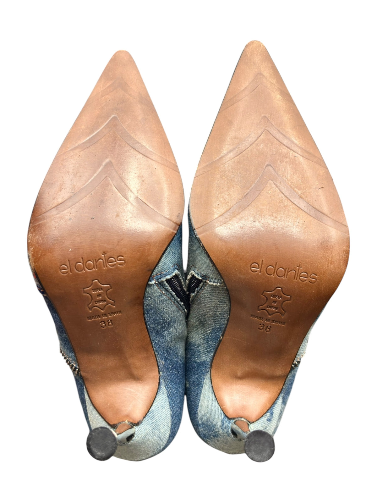 Pair of blue mid-calf denim boots with star patches and high stiletto heels.