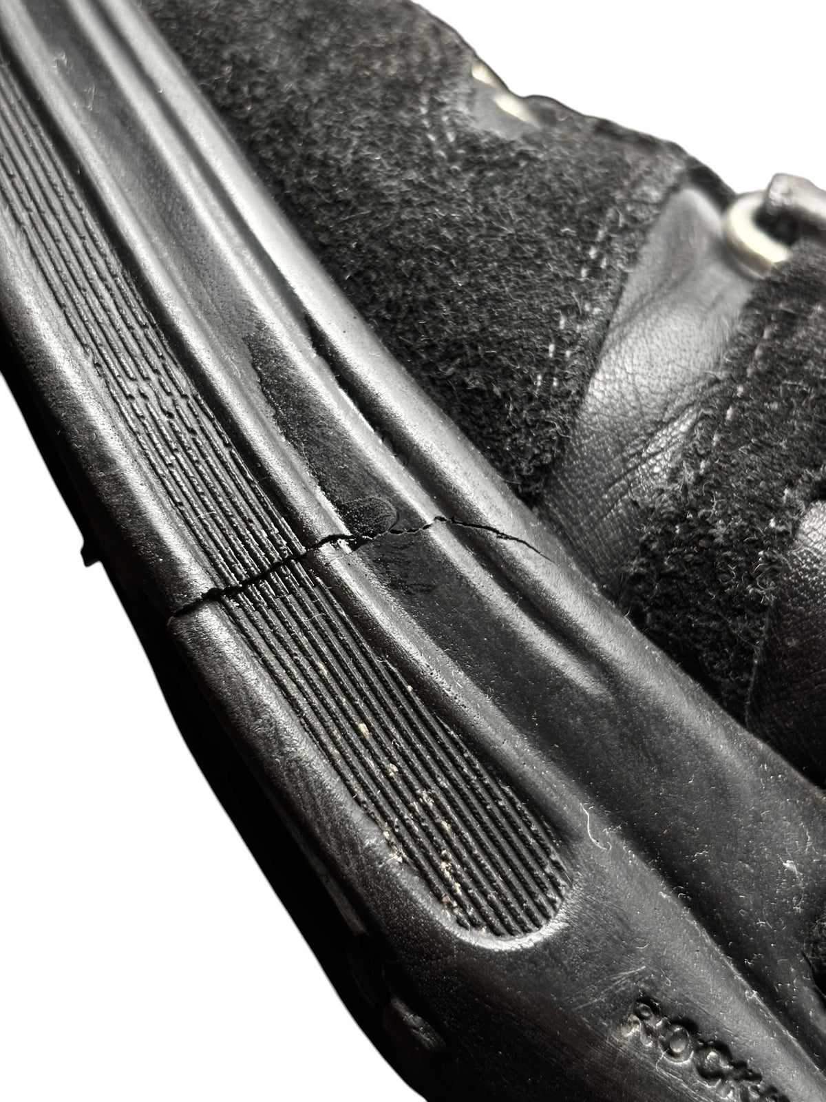 Black leather sneaker side view with ridged sole and stitched panel