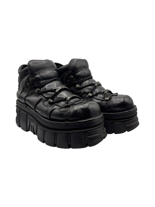 Black lace-up platform boots in three-quarter view with thick lug tread sole