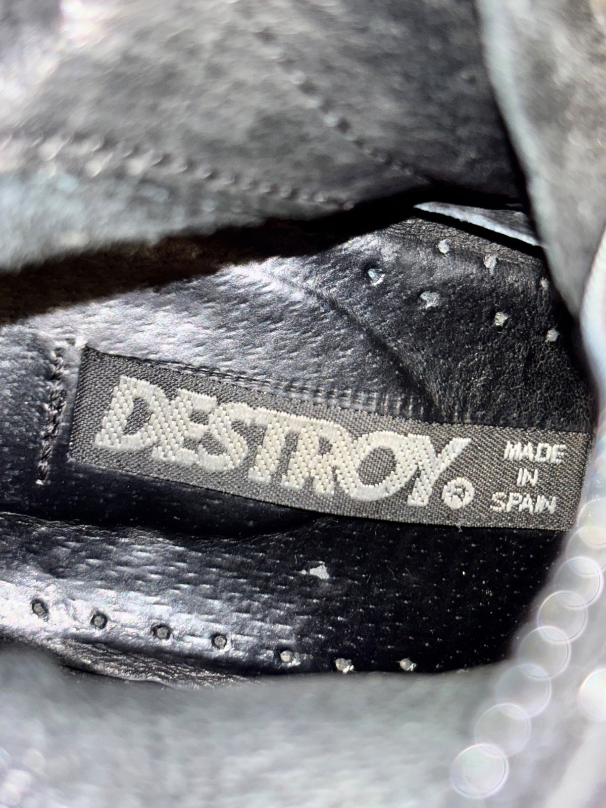 Black knee-high leather boots with Destroy brand label on the inner cuff.