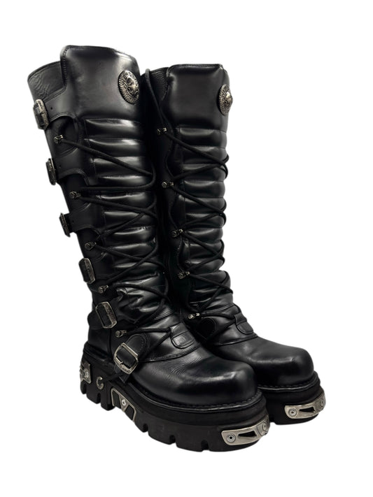 Black knee-high leather boots with lace-up front, buckles, and rugged tread sole