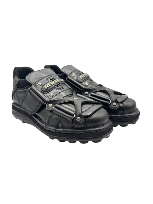 Black leather sneakers with dual straps and buckles, angled front view