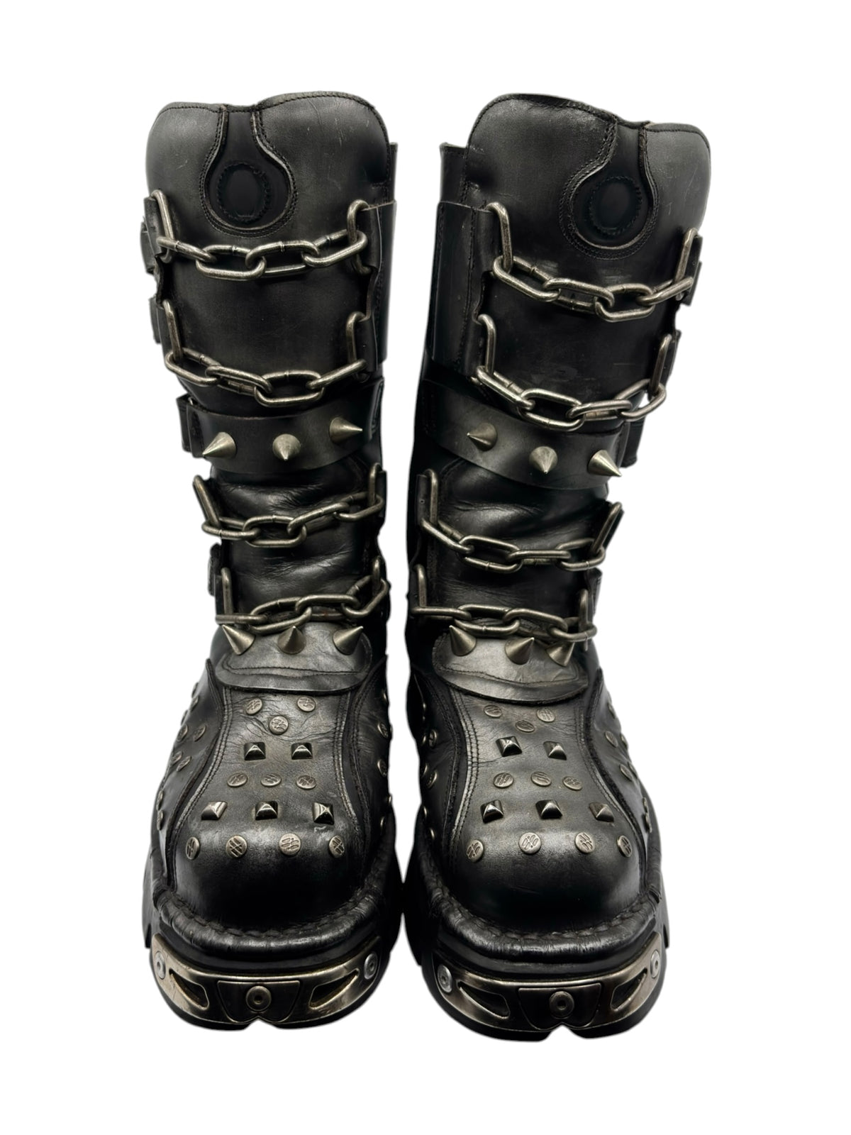 Dark studded chain boots with stacked buckle straps and circular heel detail