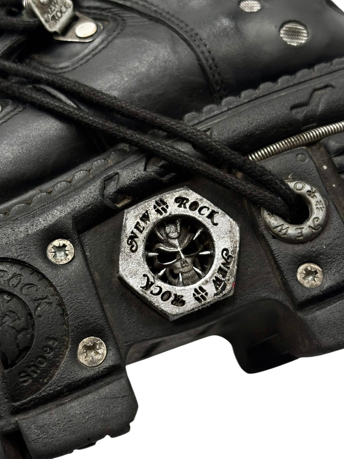 Black platform boot upper with lace, metal hardware patch, and strap details.