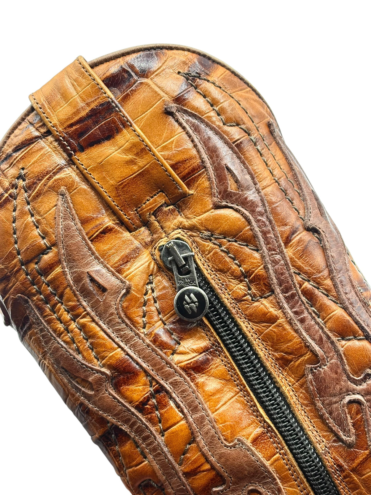 Brown boot shaft close-up showing texture, seams, and zipper pull detail