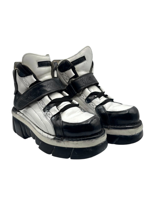 White and dark platform boots with lace-up front and two adjustable hook straps.
