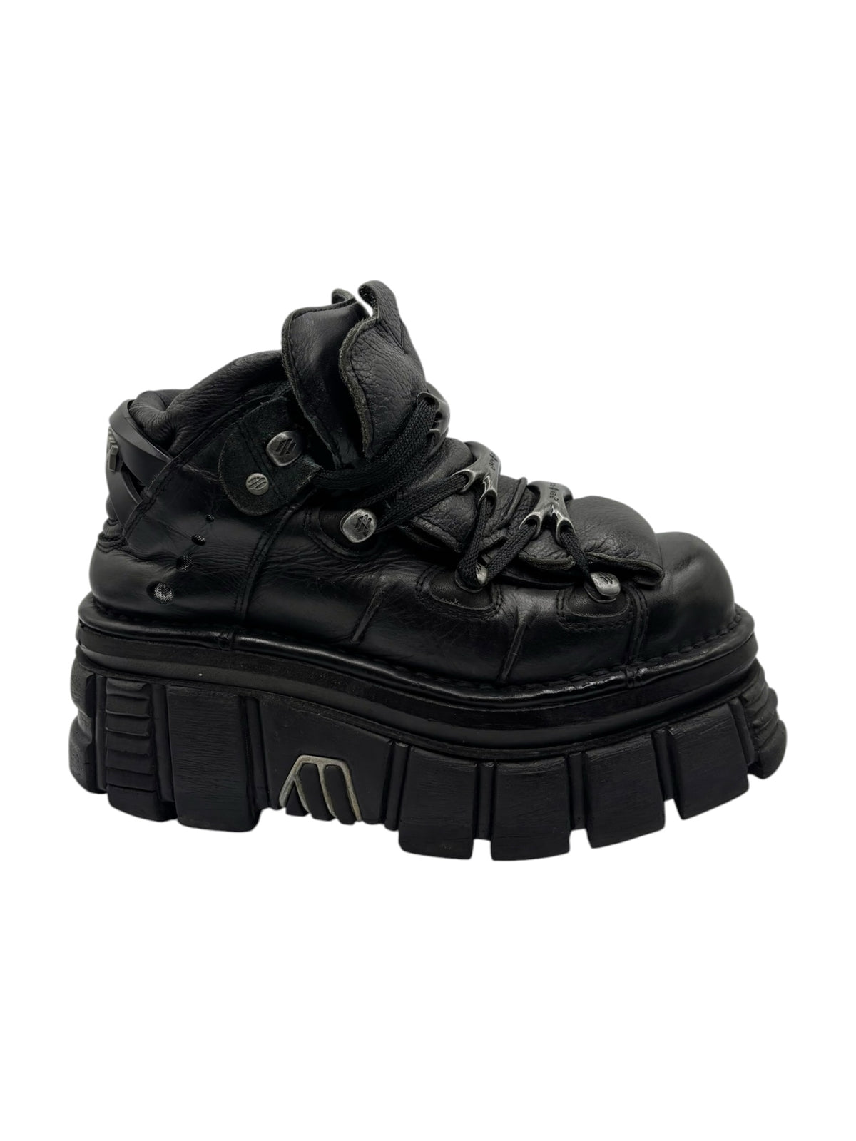 Black platform boots with lace-up closure and thick outsole with deep grooves.