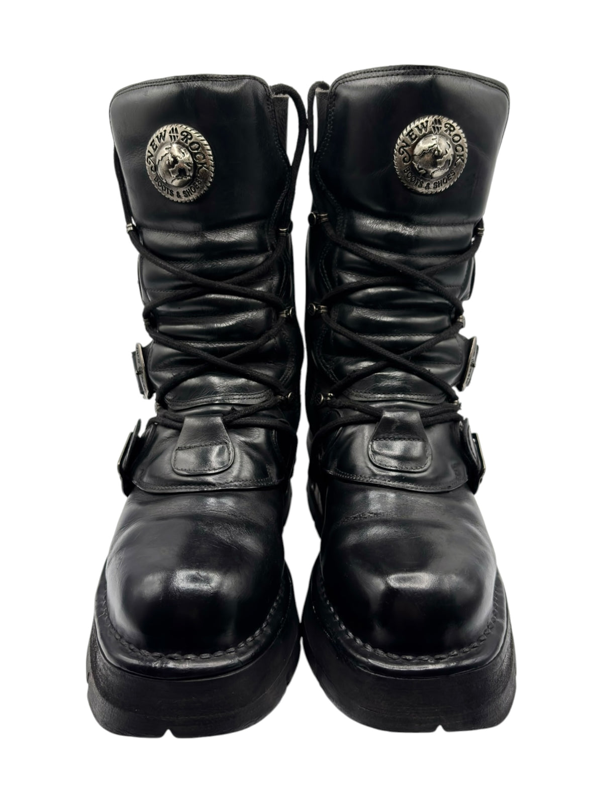 Black mid-calf boots with lace-up front and round logo patches on the ankle