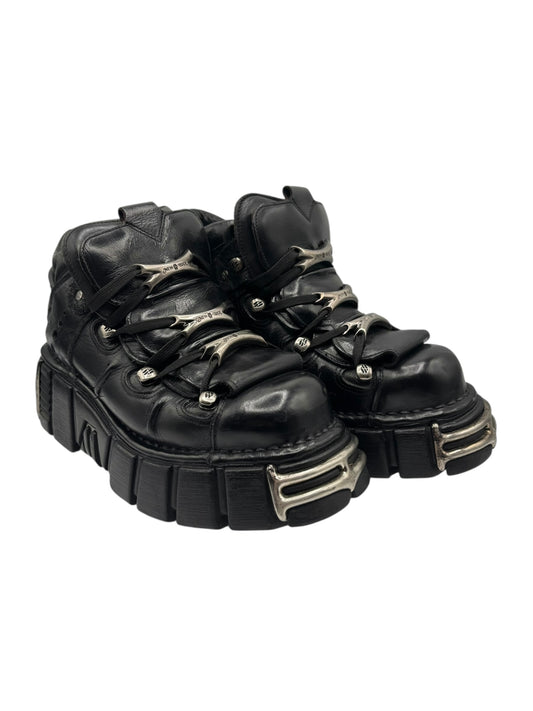Black lace-up platform boots with gold-tone metal buckles and thick treaded outsole