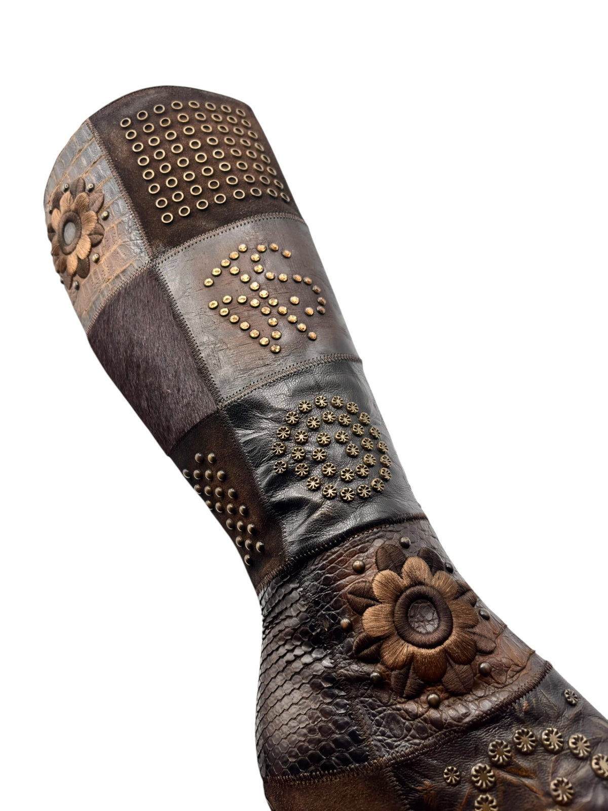 Vintage knee-high leather boots with studded straps, floral patch, and perforated top